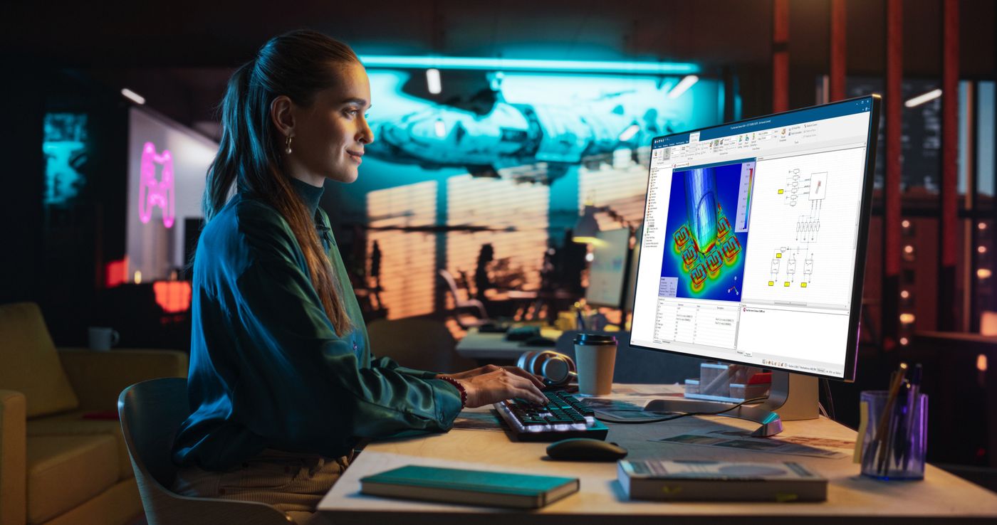 Portrait of Young Woman Sitting at Her Desk Using Desktop Comput