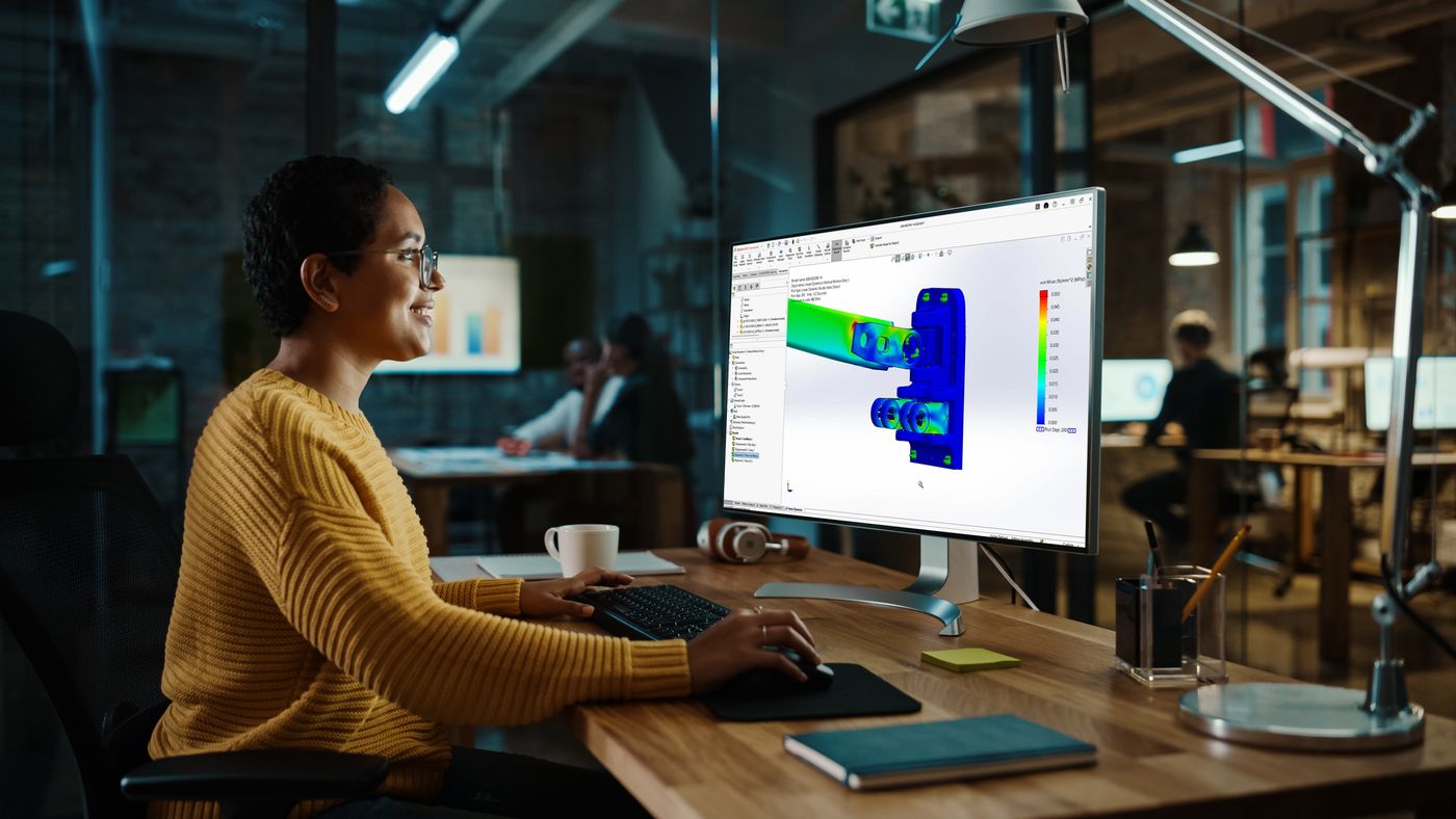 Young Multiethnic Specialist Working on Desktop Computer with Gr